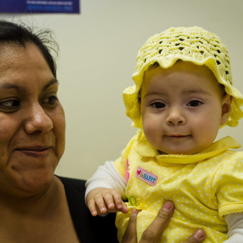 Woman holds baby up to camera