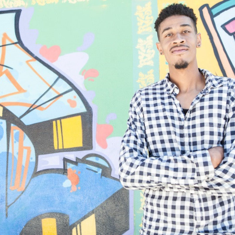 Man stands by mural