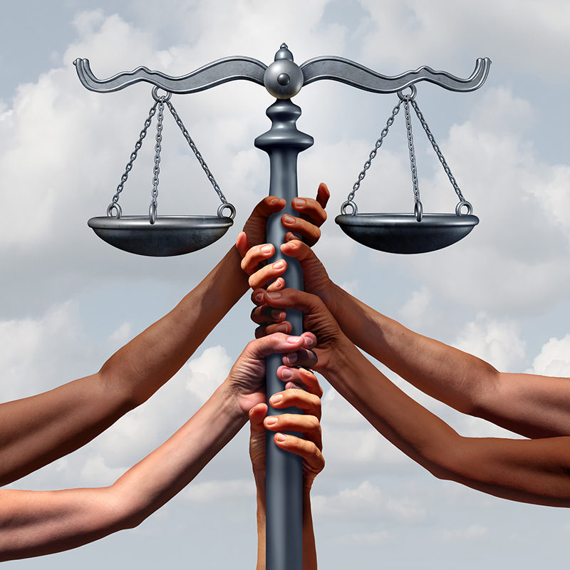 Hands grab the scale of justice.