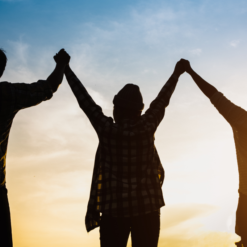 People hold hands in shadow