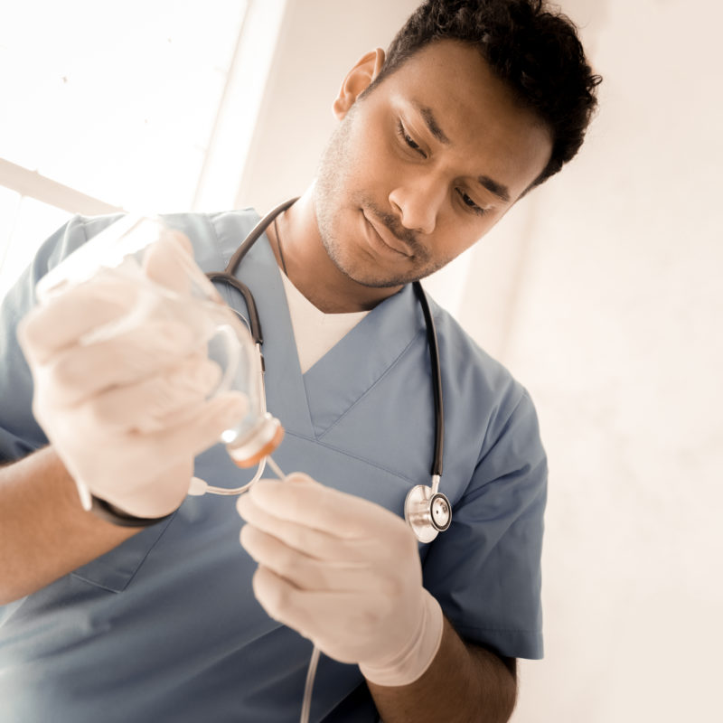 Male medical professional holds container