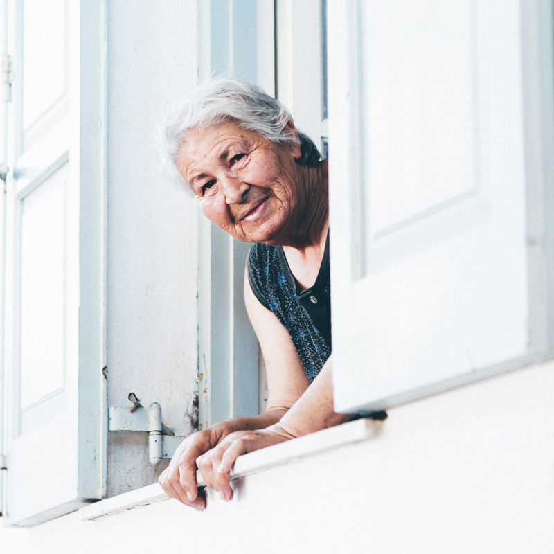 Older woman looking out a window