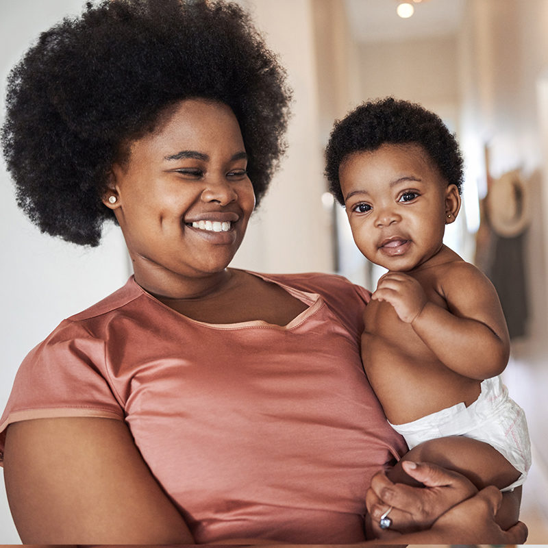 A young Black woman holding her infant