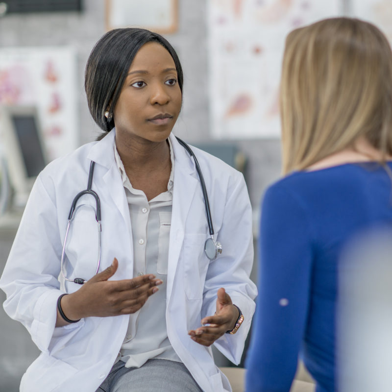 A black female doctor is talking to her patient.