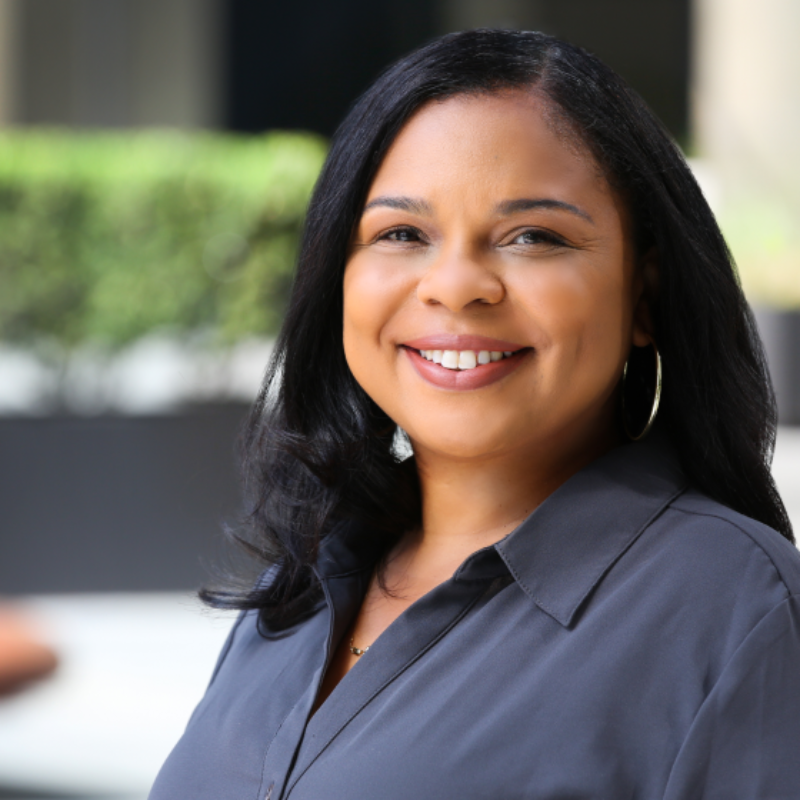 Woman smiles at camera in outdoor setting