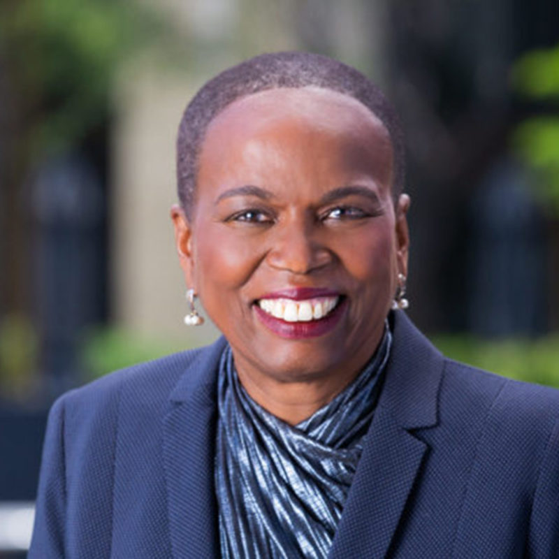 Woman outdoors in blue jacket smiles at camera